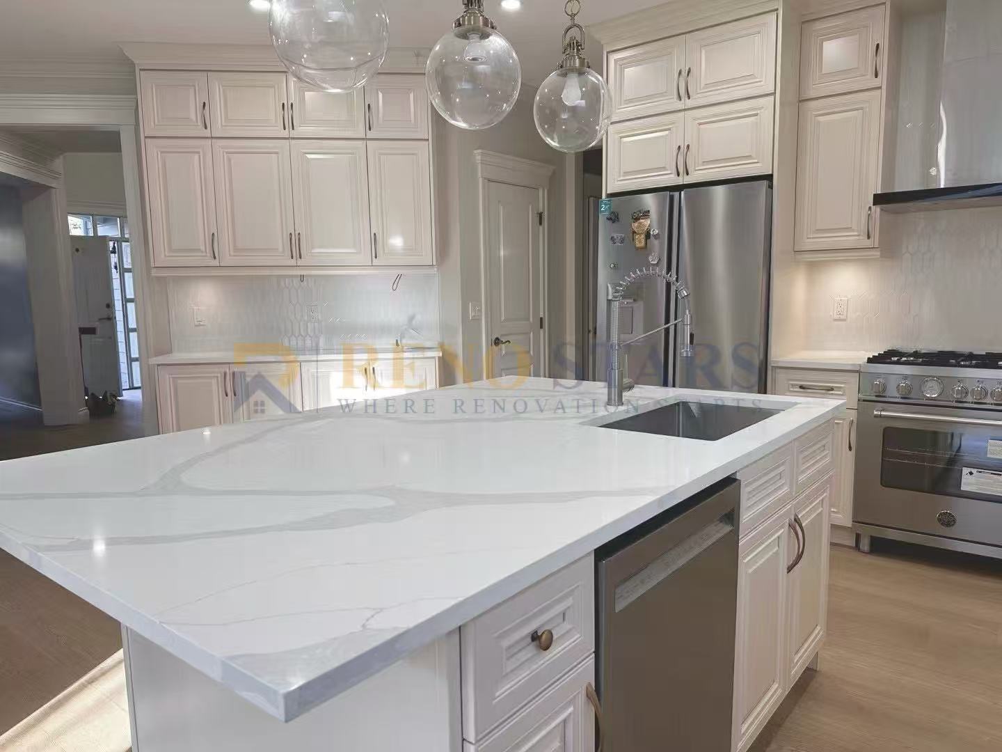 Modern kitchen featuring white cabinetry, marble countertop, and stainless steel appliances.