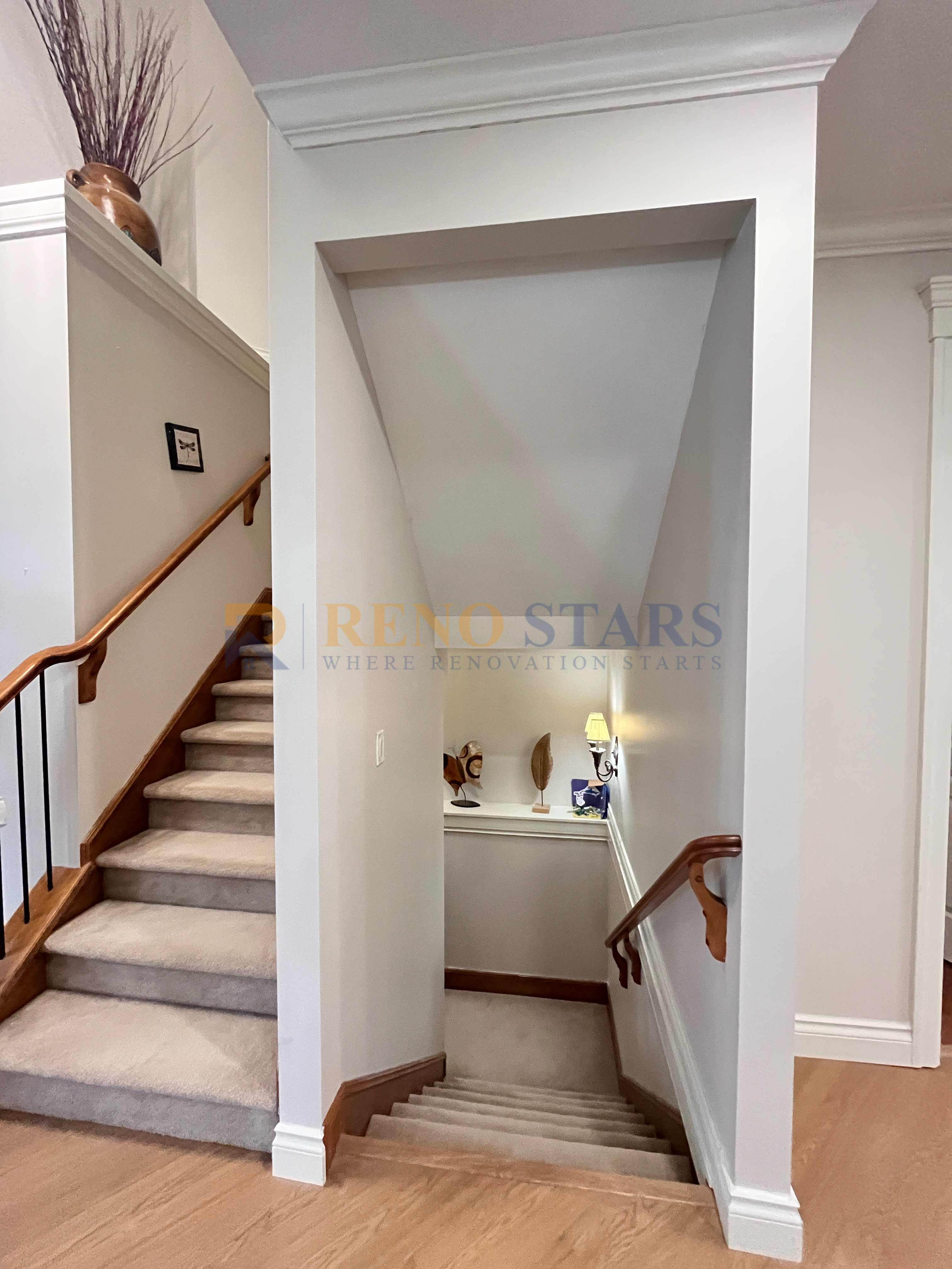 Carpeted staircase leading to a well-lit hallway with decorative elements.