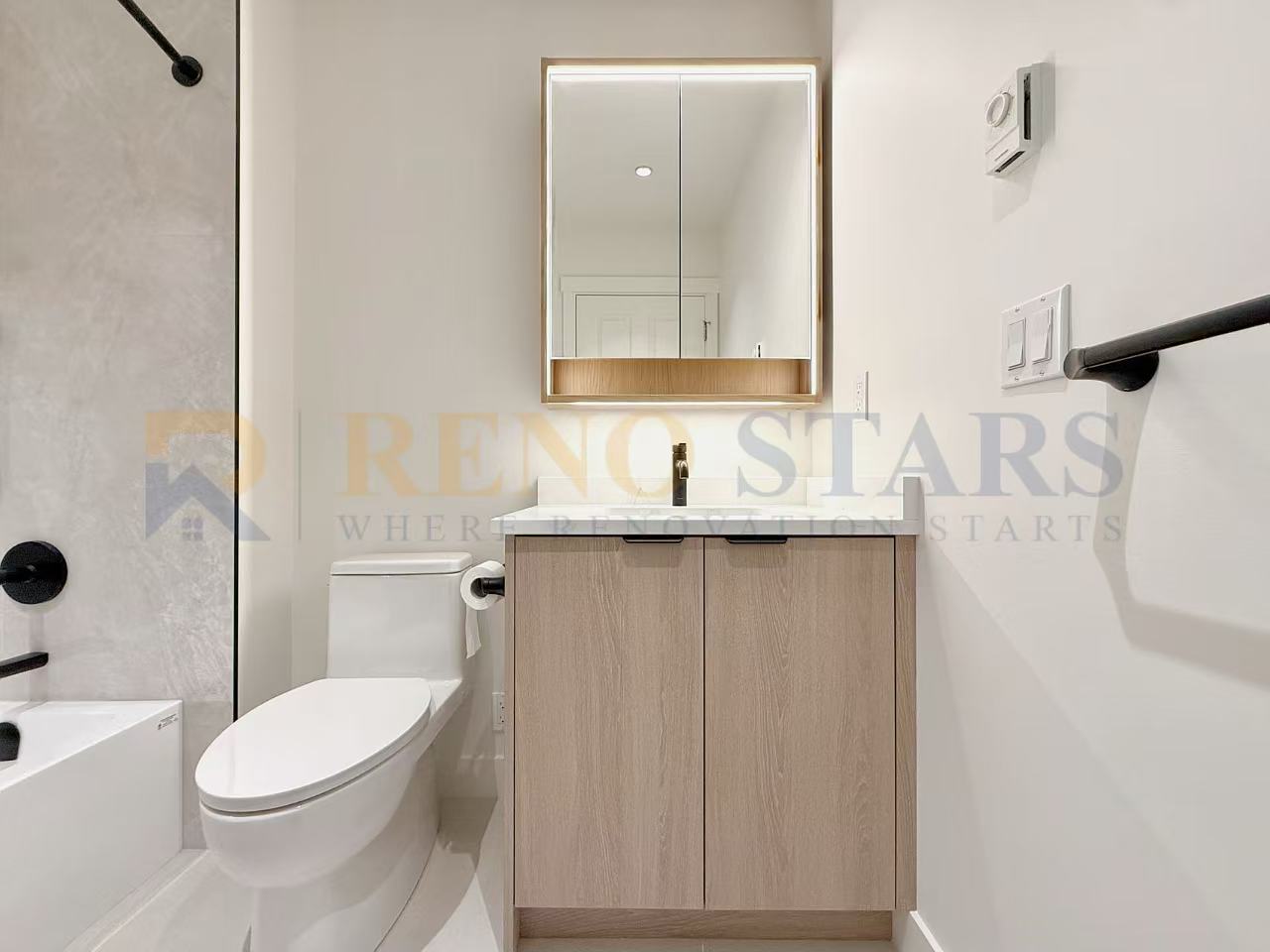 Modern bathroom featuring a wooden vanity, large mirror, and sleek fixtures.