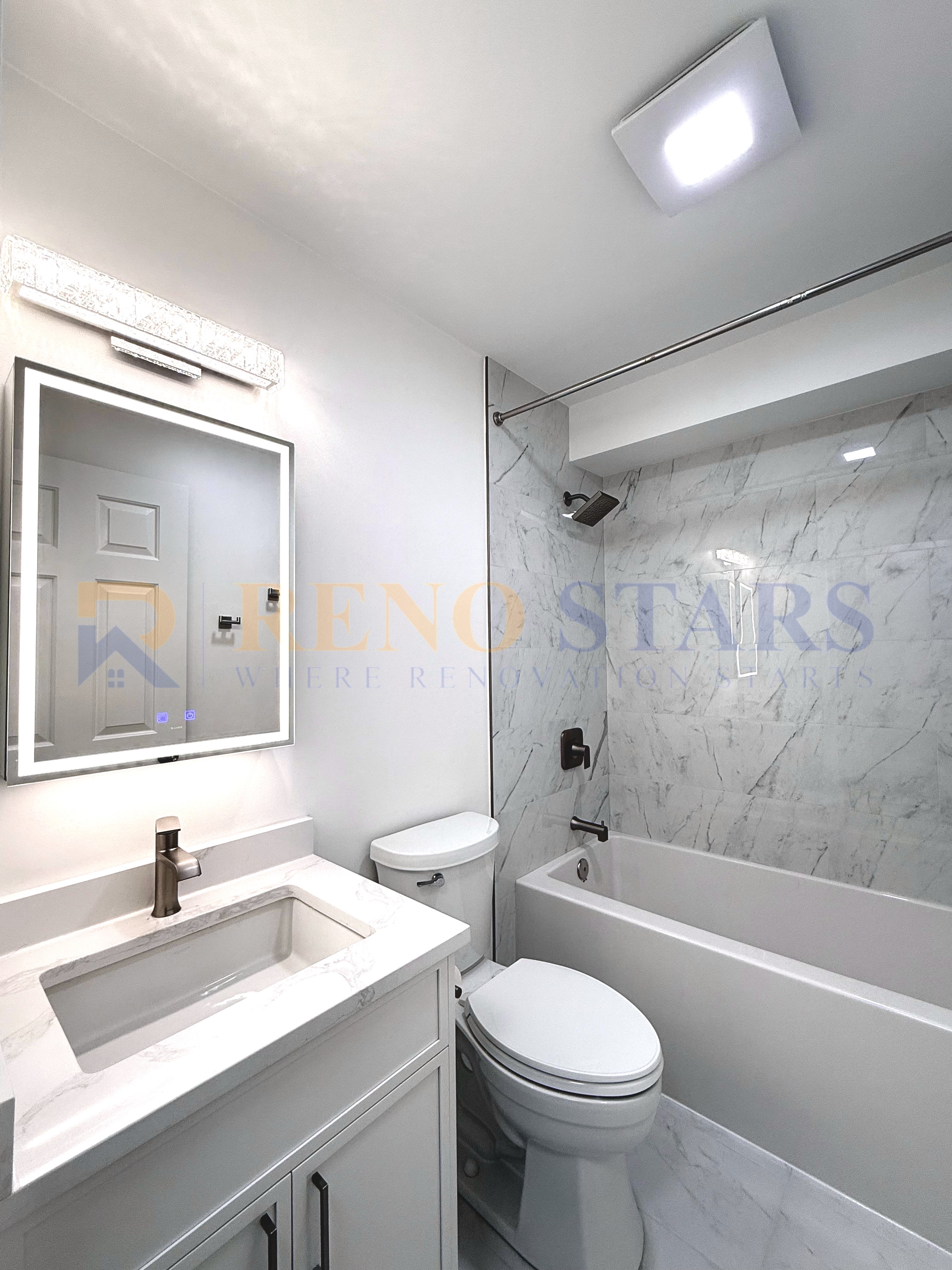 Modern bathroom featuring a marble shower, sleek vanity, and contemporary lighting.