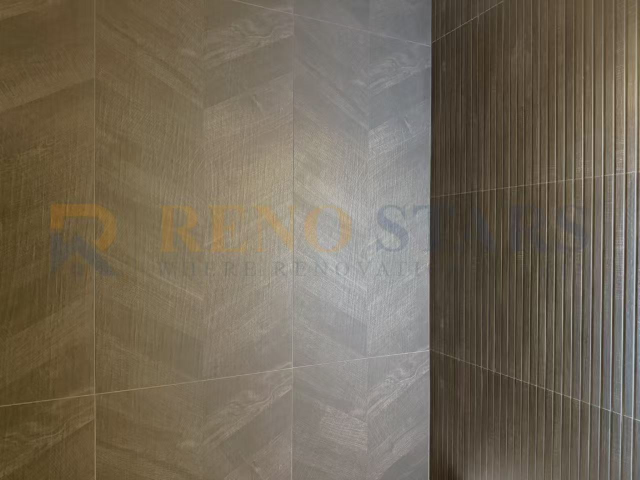 Close-up of herringbone and vertical striped wall tiles in a modern renovation.